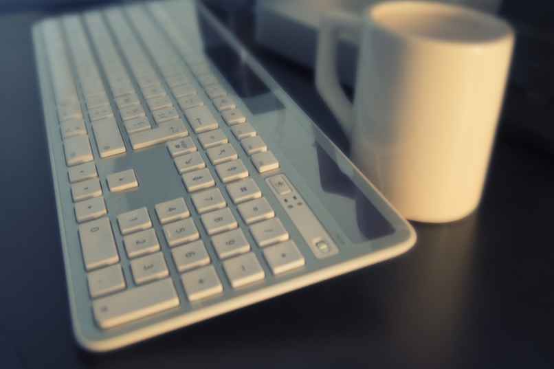 taza de cafe al lado de un teclado