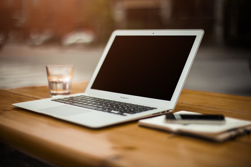 laptop blanca sobre mesa de madera