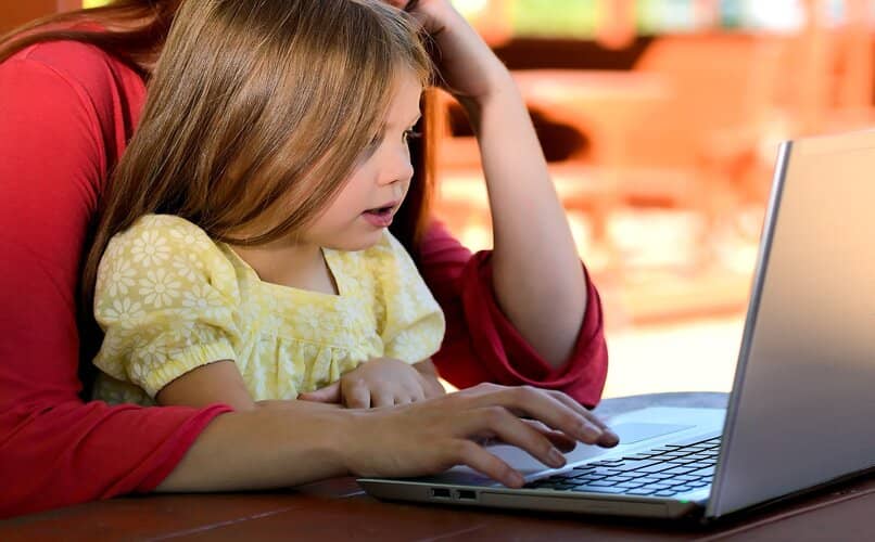 mujer y niña trabajando en word via laptop