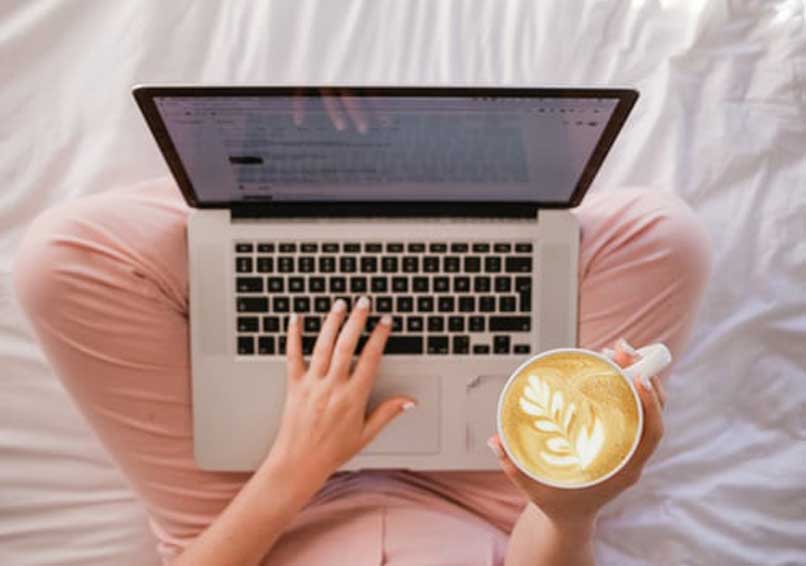 persona con laptop y cafe